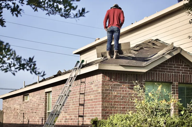 Professional roofer working on a residential roof in The Hills at Bethel